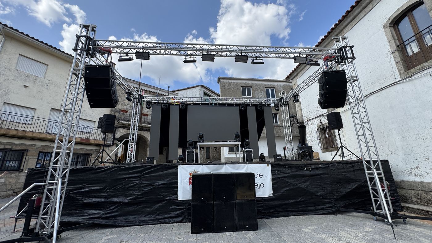 Estructura de truss con altavoces y focos de iluminación profesional montada en una plaza para un evento