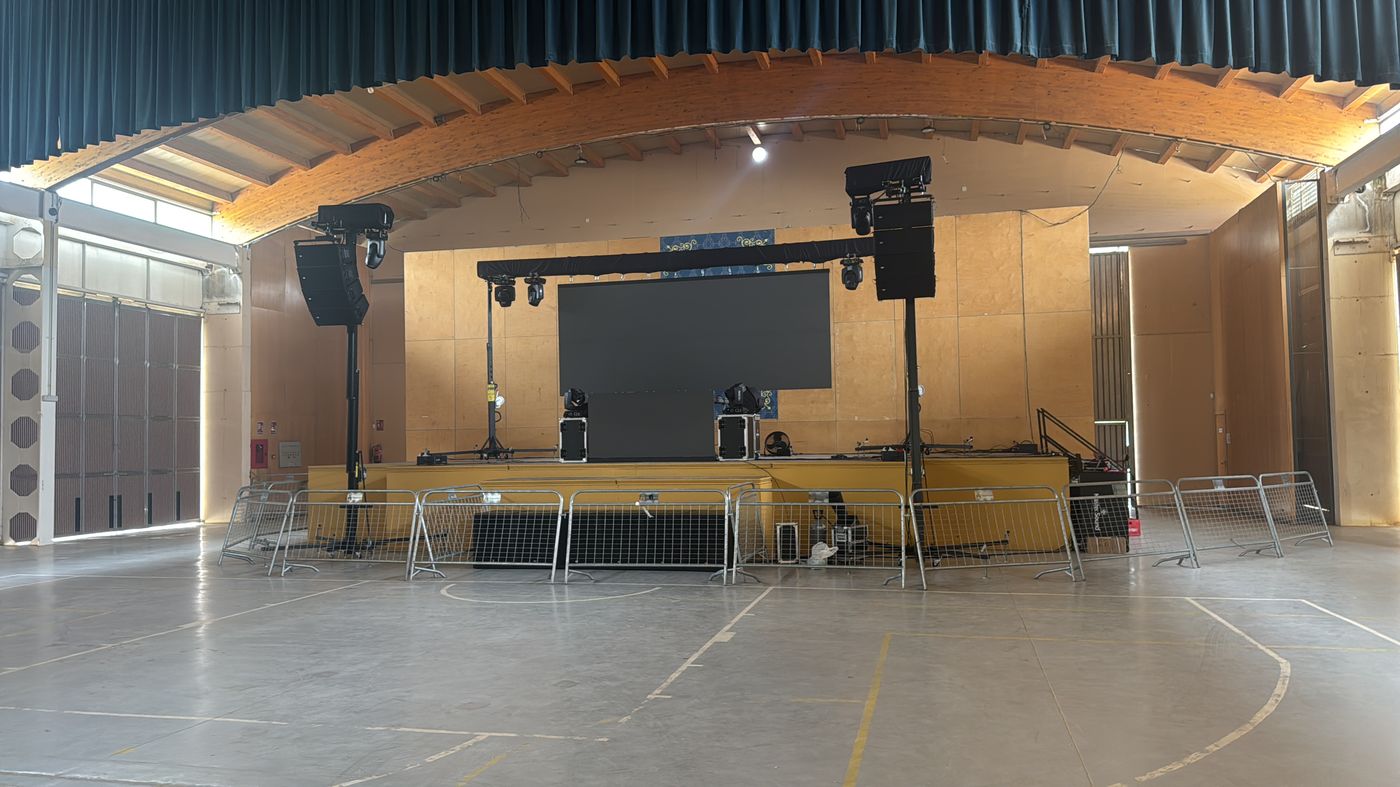 Sala amplia equipada con pantalla y altavoces line array para sonorización en directo